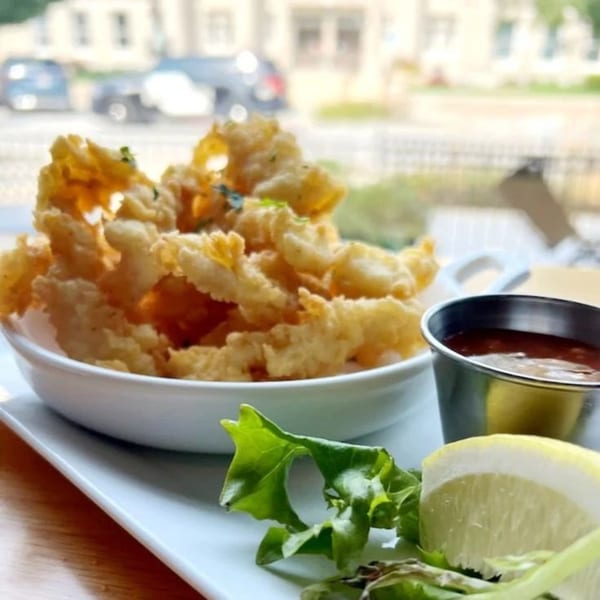 Crispy fried calamari with a side of marinara sauce, lemon, and greens at 1830 Chophouse.